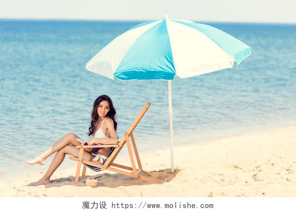有魅力的女孩穿白色比基尼在海滩椅子
